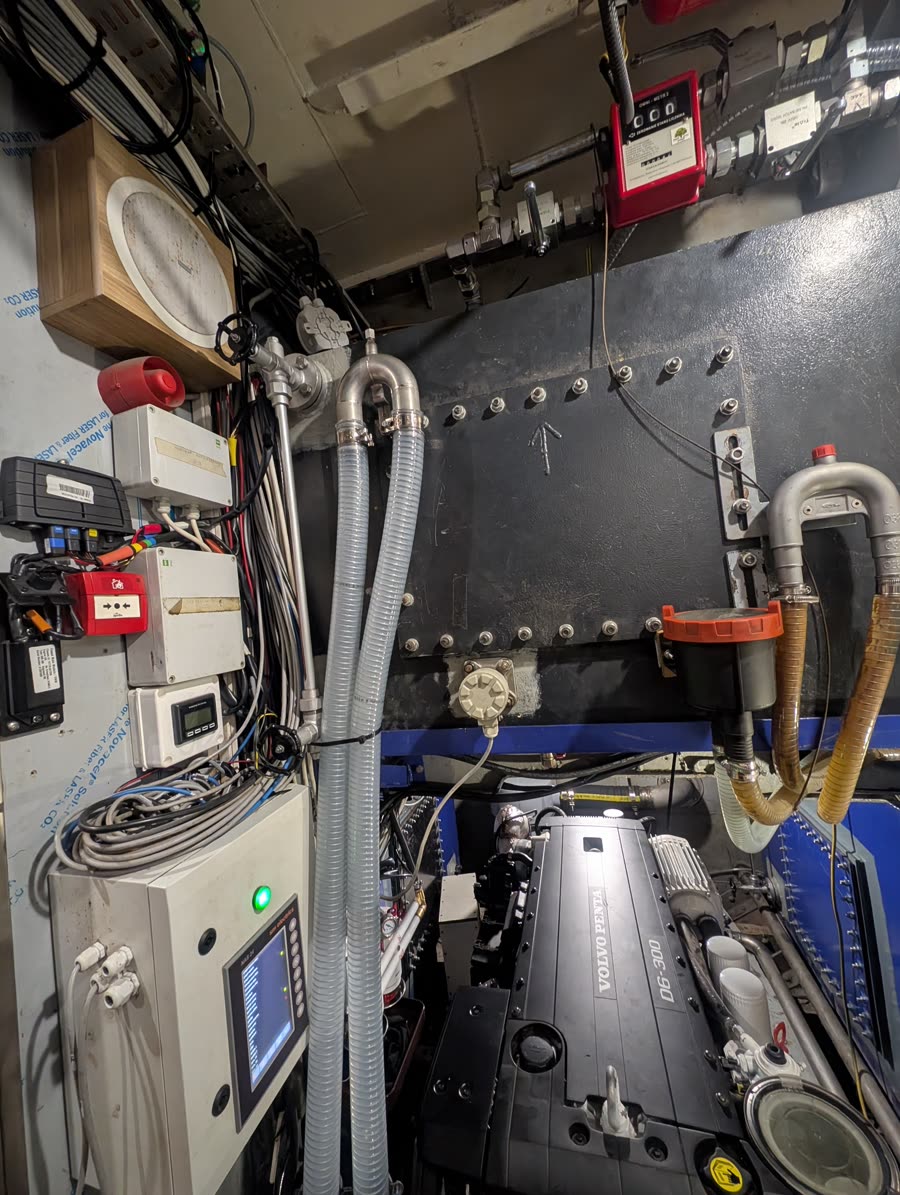 Ship engine room showing a Volvo Penta D6-300 and bulkhead-mounted control panels